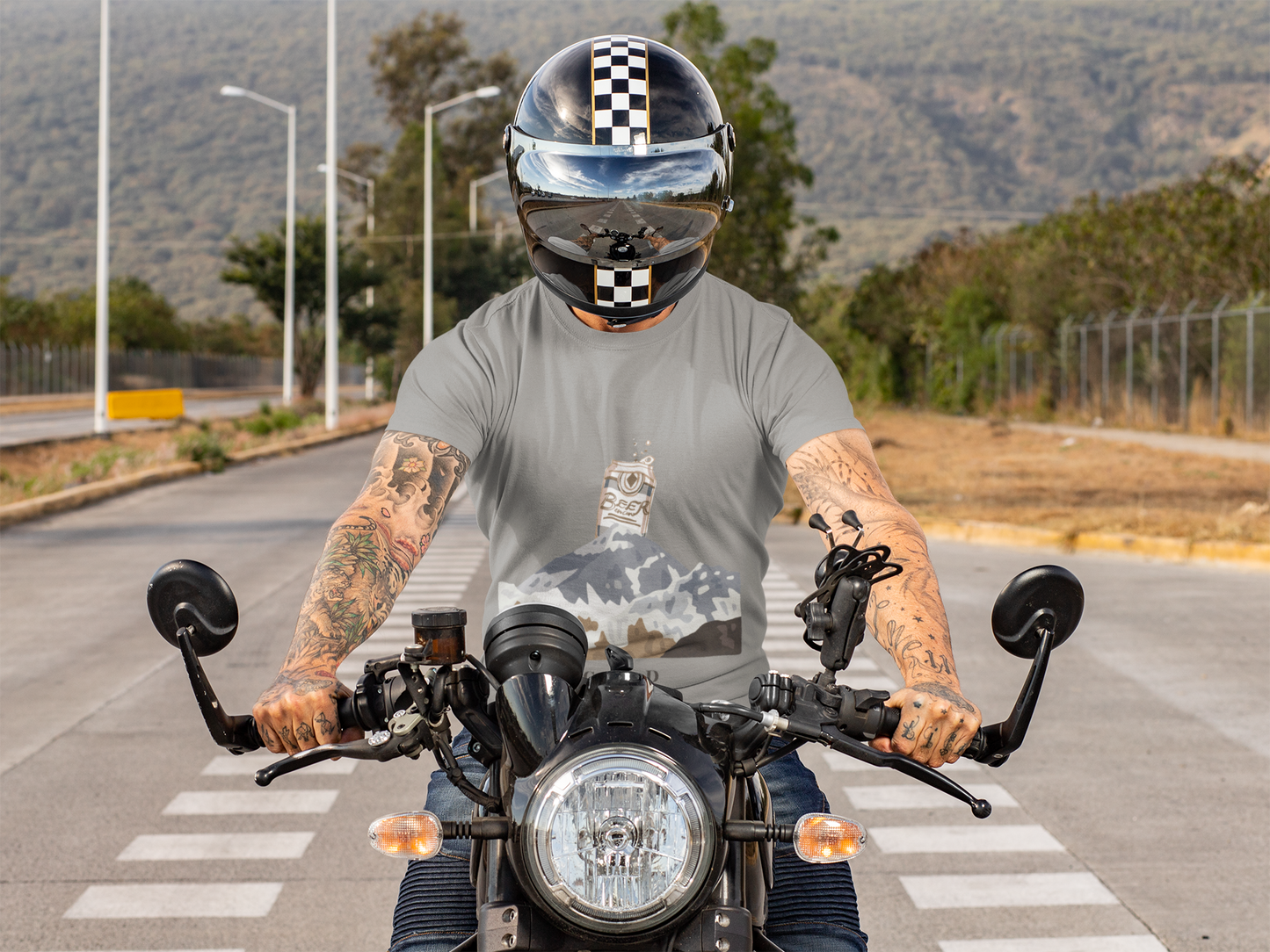 Person on a motorcycle wearing a helmet and t-shirt with a graphic design.