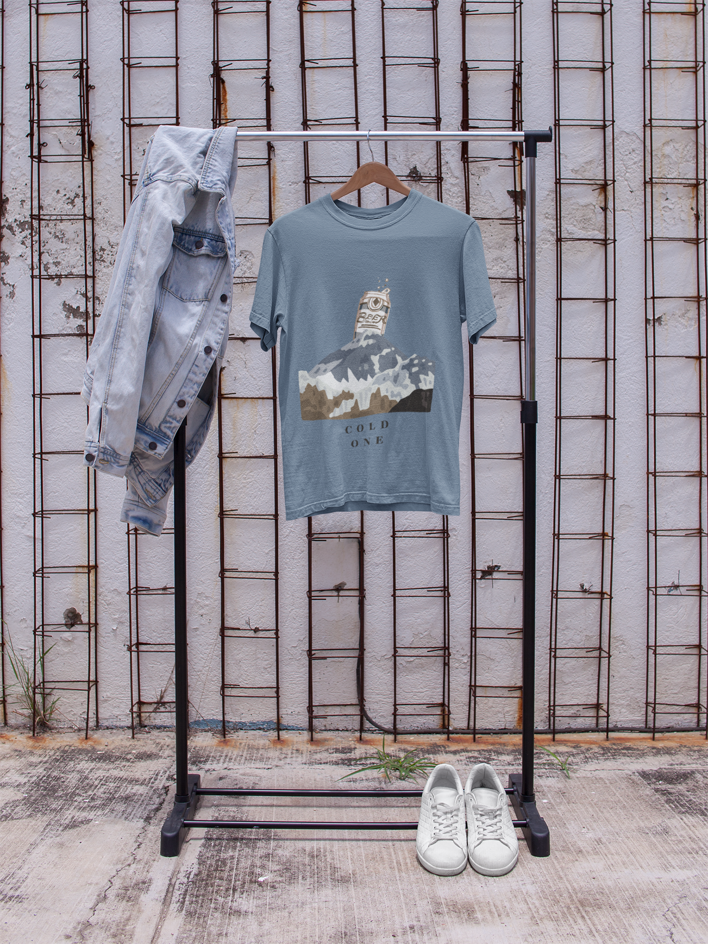 T-shirt with mountain graphic on a rack against a textured wall