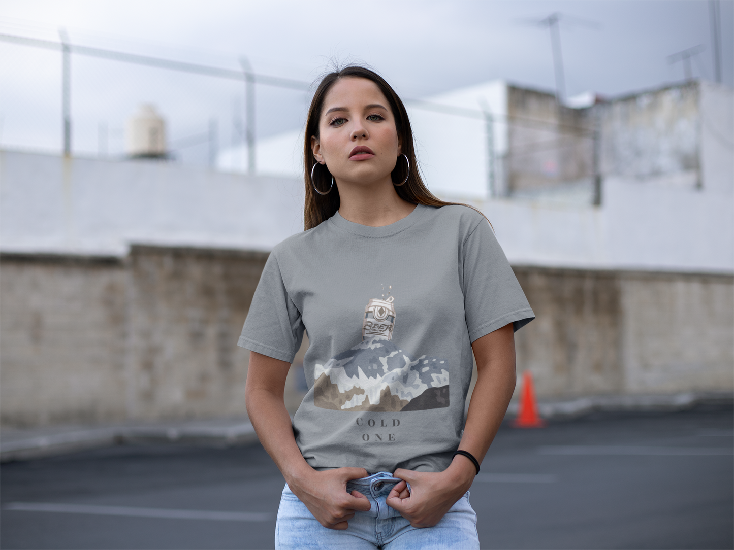 Woman wearing a gray t-shirt with a graphic design in an outdoor setting