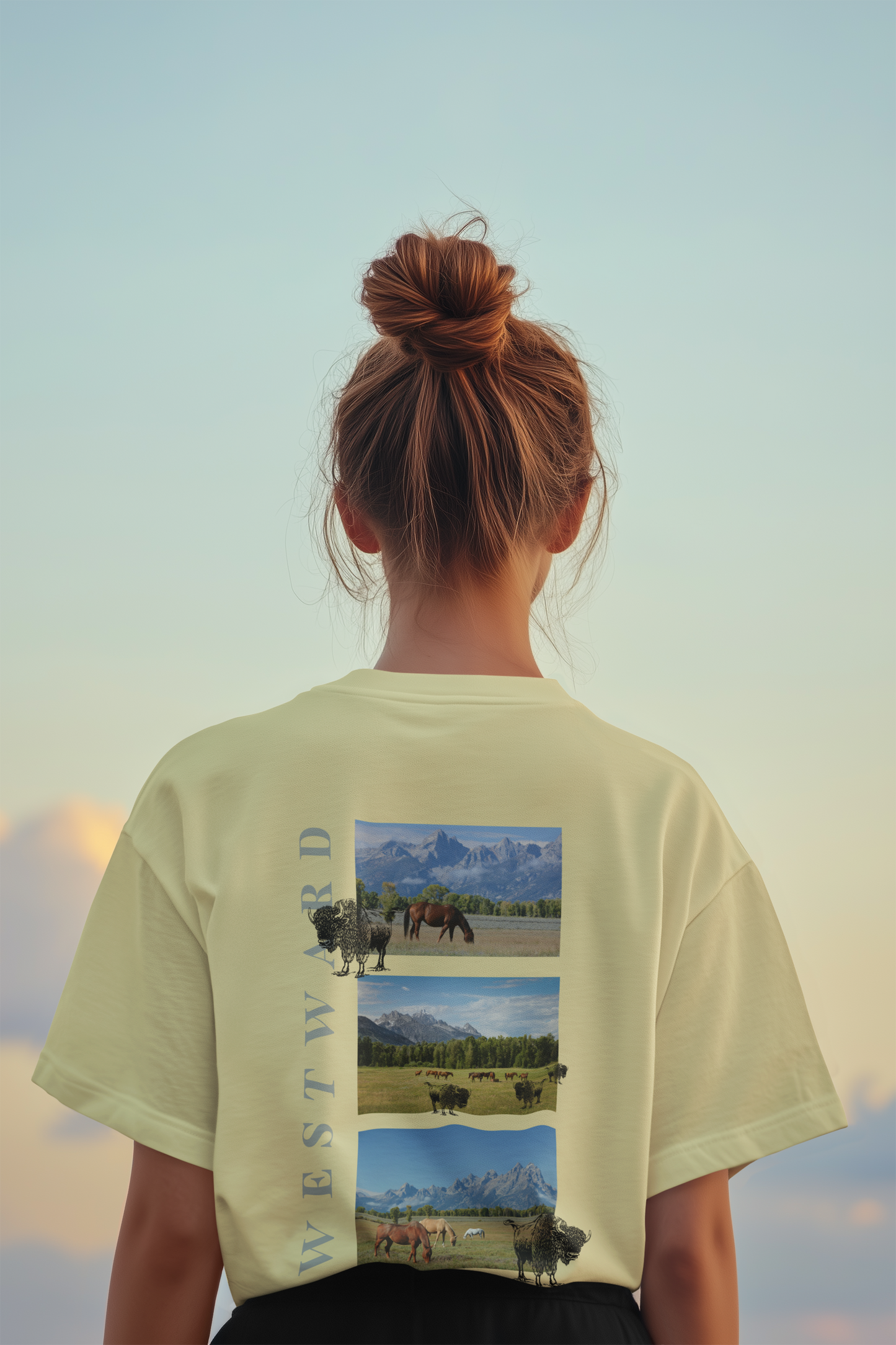 Person wearing a light green t-shirt with nature-themed graphic and text, standing against a scenic background.