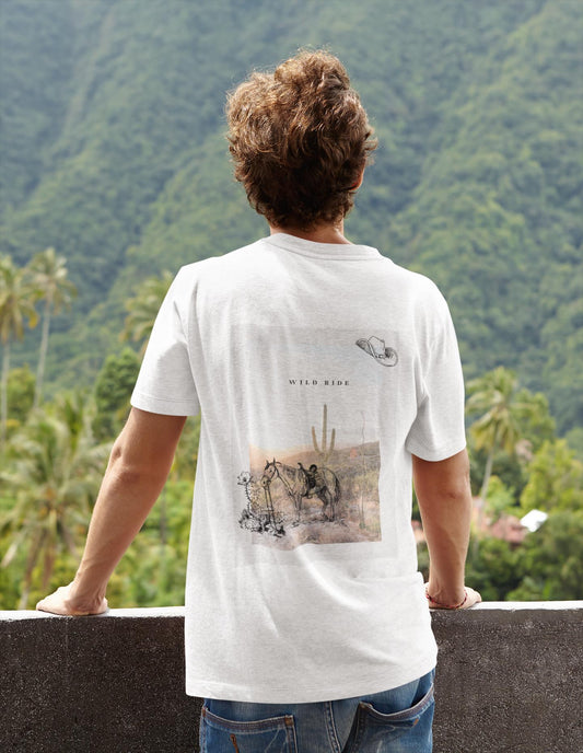 Person wearing a white t-shirt with a graphic design, standing against a scenic background of mountains and trees.